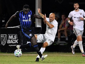Jul 21, 2020; Kissimmee, FL, USA; D.C. United midfielder Federico Higua'n (2) and Montreal Impact midfielder Victor Wanyama (2) fight for the ball during the second half at ESPN Wide World of Sports.