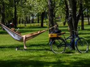 Nic Neufeld reads a book while enjoying the warm weather on a hammock in Pearce Estate Park on Thursday, May 28, 2020.
