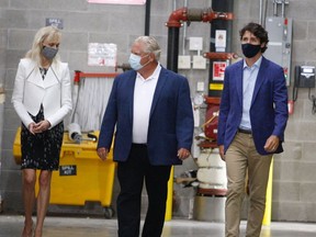 3M Canada president Penny Wise, left, speaks to Ontario Premier Doug Ford as they join Prime Minister Justin Trudeau for Friday's announcement of N95 mask production capacity at the company's Brockville tape plant.
