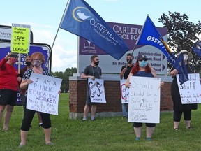 Education workers, parents and community members gather outside the Ottawa Carleton District School Board office Tuesday  to send a message to trustees.