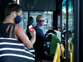 Wearing their masks and behind protective shields, OC Transpo drivers pick up riders using tap cards at the Marketplace station in Barrhaven.