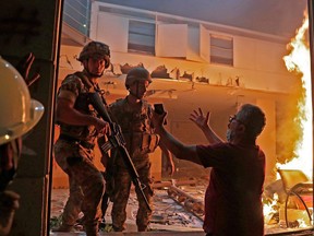 A Lebanese protester speaks to soldiers at the headquarters of the Lebanese association of banks in downtown Beirut on August 8, 2020.