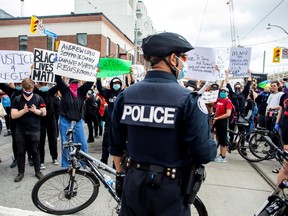 Protesters march to highlight the deaths of Toronto's Regis Korchinski-Paquet, who died after falling from an apartment building while police officers were present, and in the officer-involved deaths of Ahmaud Arbery, Breonna Taylor and George Floyd in the U.S., in Toronto on May 30, 2020.