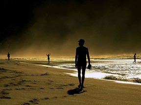 People walk on a beach in Brazil.