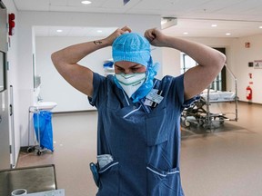 FILE: A healthcare worker puts on protective gear.