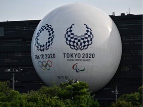 In this file photo the Tokyo 2020 Olympic and Paralympic logos are displayed on the Hinomaru driving school building in Tokyo on June 29, 2020. – With the 2020 Tokyo Summer Games pushed back a year and the uncertainty created by the novel coronavirus outbreak, the financial challenges going forward look daunting for the United States Olympic Paralympic Committee.