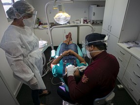 A dentist checks a patient.