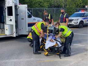 An Ottawa Paramedic Service crew treats a 14-year-old cyclist after a collision with a vehicle on Friday afternoon.