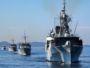 HMCS Regina (front), followed by HMCS Brandon, HMCS Naniamo, Patrol Craft Training vessel (PCT) Cougar and PCT Wolf, sail in formation in the Strait of Georgia on Canada's west coast on April 14 2020.
