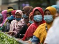 Passengers wait in line at a bus station in Kuala Lumpur, Malaysia on Aug. 11, 2020.