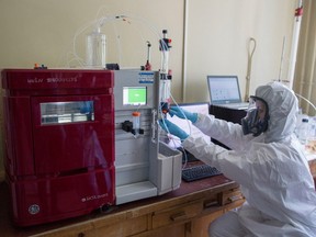 A lab technician wearing personal protective equipment (PPE) operates a chromatography machine during production of the 'Medgamal' COVID-19 vaccine, developed by the Gamaleya National Research Center for Epidemiology and Microbiology and the Russian Direct Investment Fund (RDIF), at the Gamaleya National Research Center in Moscow, Russia, on Thursday, Aug. 6, 2020.