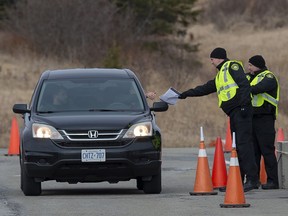 Compliance officers check vehicles at the Nova Scotia-New Brunswick border near Amherst, N.S. on April 5, 2020.