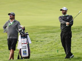With his caddy watching, Adam Hadwin, right, plays from the rough during a practice round on Tuesday at the U.S. Open in Mamaroneck, N.Y.