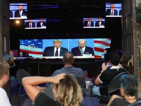 People watch a broadcast of the first debate between President Donald Trump and Democratic presidential nominee Joe Biden at an outdoor venue in West Hollywood, Calif., Tuesday night.
