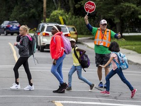 A crossing guard helps students cross the street.