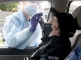 Preston Bougie, 11, of Carleton Place, gets his nose swabbed by paramedic Jessica Foran to test for COVID-19 on Friday.