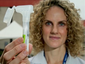 Dr. Stephanie Johnson-Obaseki, a researcher and head and neck cancer surgeon at The Ottawa Hospital, shows the COVID-19 saliva test in front of the Brewer testing centre Tuesday.