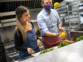 Ottawa Kitchen Party co-chair Chris Klotz and Daniela Manrique, owner and chef of the Soca Kitchen, joke around while prepping food at the Holland Avenue restaurant.