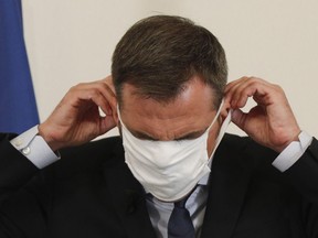 France's Health Minister Olivier Veran returns a protective mask to its place after addressing media representatives at The Ministry of Health in Paris on September 17, 2020, on the situation of the novel coronavirus in France.