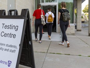 Three Western students enter the COVID-19 testing centre on campus in London, Ont.