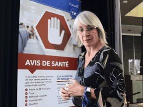 Federal Health Minister Patty Hajdu walks past a COVID-19 health advisory sign on Tuesday, September 15, 2020.