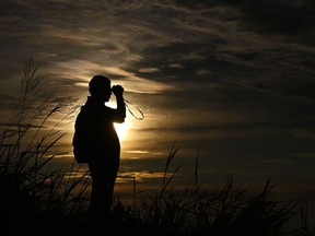 FILE: A man's silhouette is seen against the sky during sunrise.