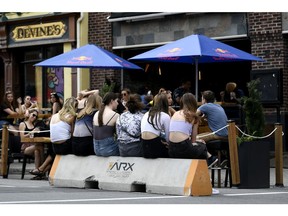 People wait for a table at a bar's outdoor patio in the ByWard Market during the summer.