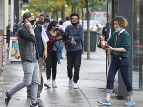 People walk along Ste. Catherine Street in Montreal on Monday.