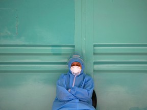 A medical worker wearing personal protective equipment (PPE) rests from collecting swab samples to be tested for the coronavirus disease (COVID-19), as the outbreak continues in Jakarta, Indonesia, September 29, 2020.