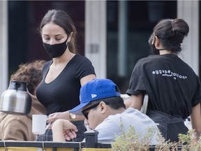 A server wears a face mask at a restaurant in Montreal, Saturday, September 26, 2020, as the COVID-19 pandemic continues in Canada and around the world.