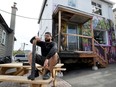 Hassan (Bongo) Bicher poses for a photo in front of his torched restaurant Super Salads on Preston Street in Ottawa on Monday.