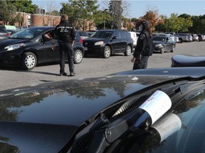 Ottawa bylaw officers hand out warnings to drivers who are parked illegally at the COVID-19 testing facility at Brewer Arena on Wednesday Sept 23, 2020.
