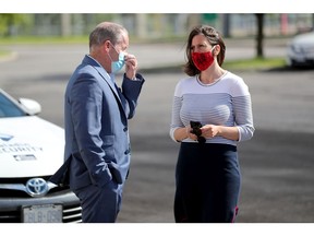 Cameron Love, CEO of The Ottawa Hospital, talks to Dr. Vera Etches, Medical Officer of Health for Ottawa,  after a recent press conference at the drive-through testing centre on Coventry Road.