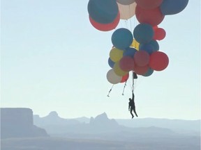 Extreme performer David Blaine hangs with a parachute under a cluster of balloons during a stunt to fly thousands of feet into the air in a still image from video taken over Page, Arizona, U.S. on Tuesday.