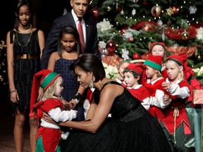FILE PHOTO: U.S. first lady Michelle Obama greets a child dressed as an elf at the Christmas in Washington Celebration at the National Building Museum in Washington December 12, 2010.