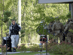 RCMP officers prepare to enter an apartment complex in connection with the mailing of ricin to President Trump on Monday in St. Hubert, Quebec.