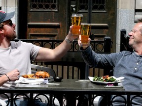 Juriain Bornet and Rene Vantol are seen cheering their drinks while enjoying the patio at James Joyce Irish Pub