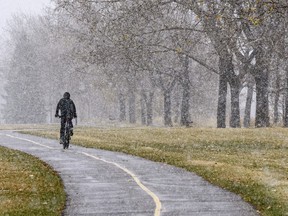 A cyclist rides in light flurries.