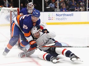 FILE: Devon Toews #25 of the New York Islanders takes down Richard Panik #14 of the Washington Capitals  during the third period at NYCB Live's Nassau Coliseum on October 04, 2019 in Uniondale, New York. The Capitals defeated the Islanders 2-1.