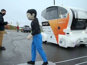 Area X.O technical project manager Tanissan Thavathurai moves a life-size figure across a road to test the auto-braking of an autonomous shuttle.