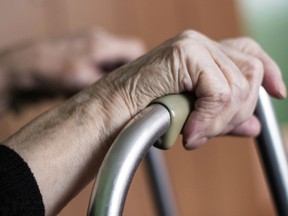 A stock image of a senior using a walker for support.