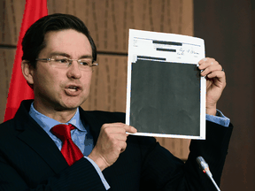 Conservative MP Pierre Poilievre holds up redacted documents relating to the WE Charity affair in August. The Conservatives are pushing to have a neutral party determine if any information was improperly withheld.