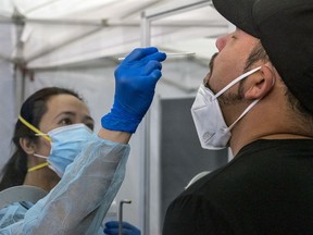 A medical worker administers a rapid Covid-19 test to a traveler at San Francisco International Airport on Thursday, Oct. 15, 2020.