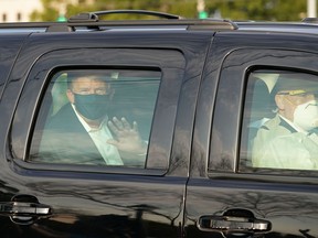 President Trump waves from the back of a car in a motorcade outside of Walter Reed Medical Center in Bethesda, Maryland on October 4, 2020.