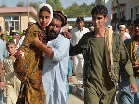 In this photo taken on Oct. 3, an injured child is carried to a hospital following a car bomb attack in the Ghani Khel district of Nangarhar province, Afghanistan. The Taliban are pushing for a return to power.