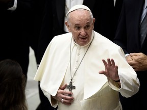 In this file photo taken on Oct. 7, 2020 Pope Francis gestures to worshippers as he holds a limited public audience inside Paul VI Hall at the Vatican during the COVID-19 infection, caused by the novel coronavirus.