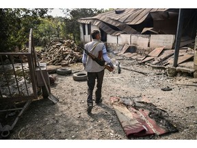 An armed villager arrives at a neighbour's home destroyed by shelling following ongoing fighting between Armenia and Azerbaijan over the disputed region of Nagorno-Karabakh, in the Martakert region on Oct. 15.