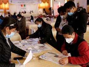 Members of the Departmental Electoral Tribunal count votes after a nationwide election in La Paz, Bolivia, Oct. 21.
