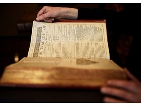 FILE PHOTO: A worker poses with a first edition of the First Folio, the first collected edition of William Shakespeare's works, containing 36 plays, at Christie's auction house in London, Britain April 19, 2016.