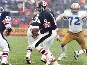 Chris Issac of the Ottawa Rough Riders prepares to hand the football to a teammate during a 1983 CFL game against the Winnipeg Blue Bombers.